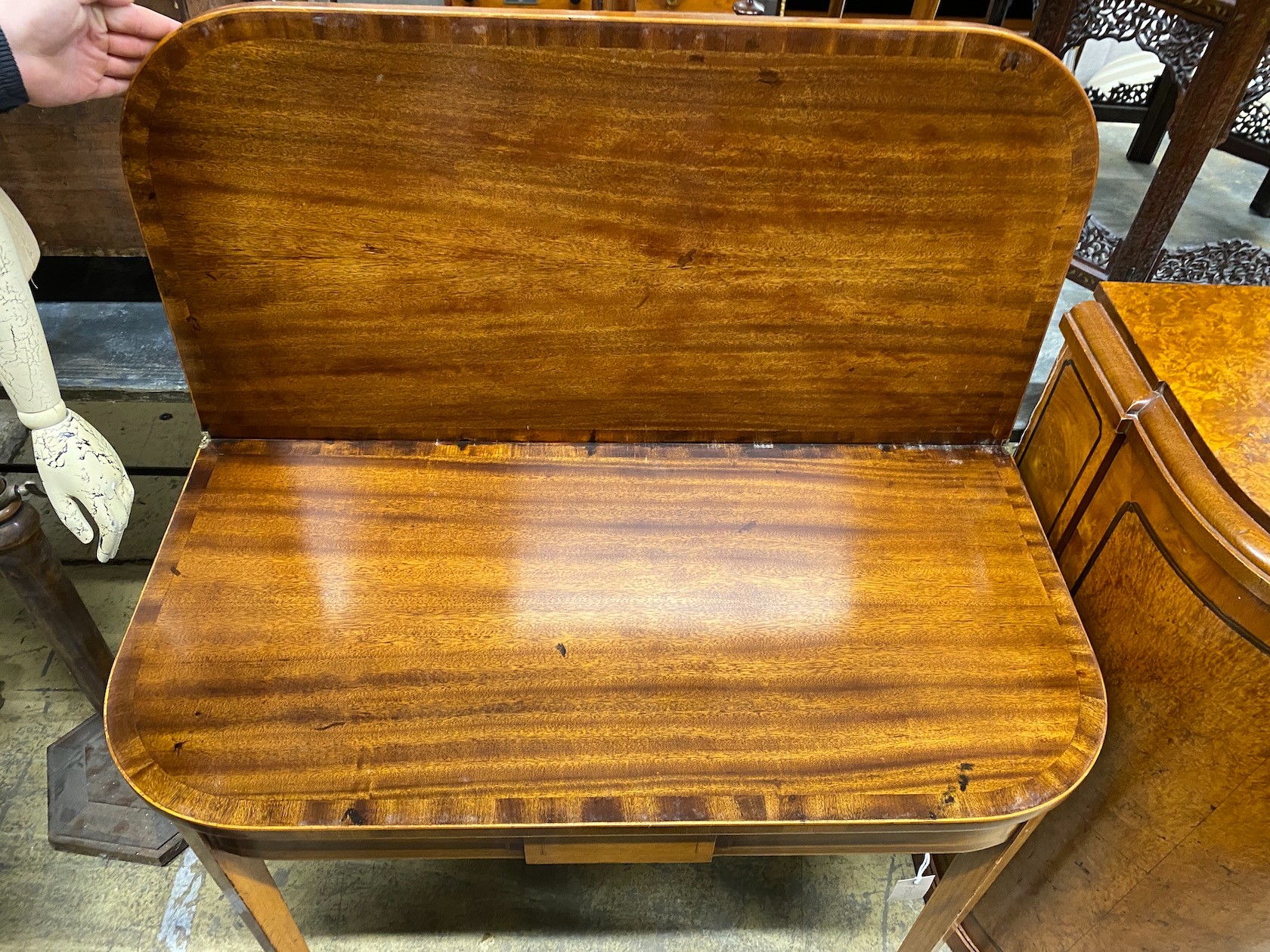 A George III style banded mahogany D shaped folding tea table, width 91cm, depth 46cm, height 74cm